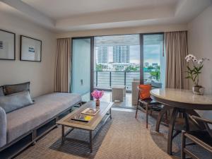 
a living room filled with furniture and a large window at Riva Surya Bangkok - SHA Extra Plus in Bangkok
