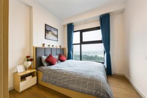 a bedroom with a bed with a large window at Thoc Ecopark Blue home 0918- with Golf course View in HÆ°ng YÃªn