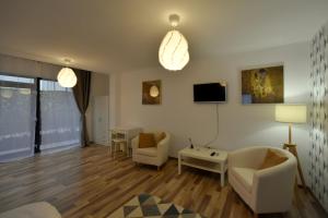 sala de estar con sofá, sillas y TV en Neferprod Apartments - IS - CAM 05, en Timisoara