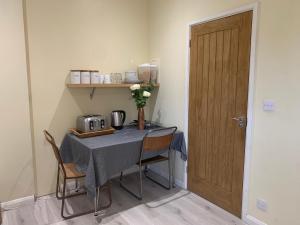 Southernwood - Wantage Road Studio 2 في ديدكوت: طاولة في غرفة مع طاولة مع كراسي وباب