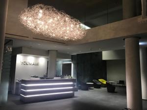 a lobby with a large chandelier and tables and chairs at YOUMAMI Suite Hotel in Giulianova