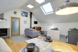 a kitchen and living room with a table and chairs at The Loft at Ard Gleann in Kirkistown