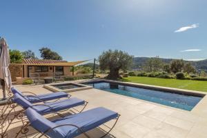 a swimming pool with lounge chairs and a house at Villa Suzanne in La Garde-Freinet