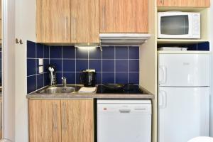 a small kitchen with a sink and a refrigerator at Résidence Pierre & Vacances Premium Port Prestige in Antibes
