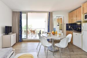 a kitchen with a table and chairs in a room at Résidence Pierre & Vacances Premium Port Prestige in Antibes