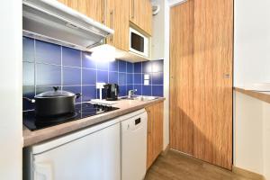 a kitchen with a stove and a sink at Résidence Pierre & Vacances Premium Port Prestige in Antibes