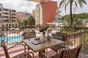 a balcony with a table and chairs and a pool at Résidence Pierre & Vacances Premium Port Prestige in Antibes