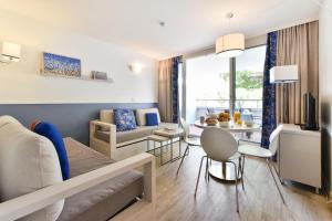 a living room with a couch and a table at Résidence Pierre & Vacances Premium Port Prestige in Antibes