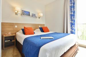 a hotel room with a bed with a book on it at Résidence Pierre & Vacances Premium Port Prestige in Antibes