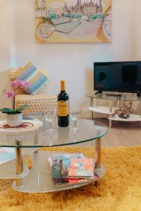 a glass table with a bottle of wine and wine glasses at Spacesavers in Sheffield