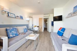 a living room with a couch and a table at Résidence Pierre & Vacances Premium Port Prestige in Antibes
