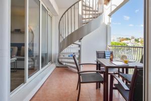 a balcony with a table and chairs and a staircase at Résidence Pierre & Vacances Premium Port Prestige in Antibes