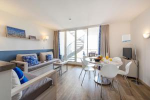 a living room with a couch and a table at Résidence Pierre & Vacances Premium Port Prestige in Antibes