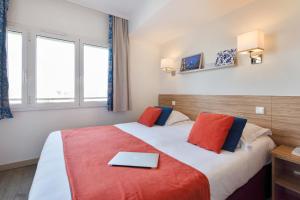 a hotel room with a bed with a laptop on it at Résidence Pierre & Vacances Premium Port Prestige in Antibes