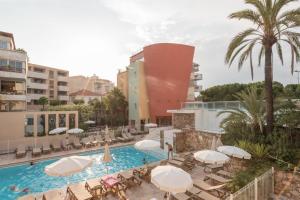 a pool with chairs and umbrellas in a resort at Résidence Pierre & Vacances Premium Port Prestige in Antibes