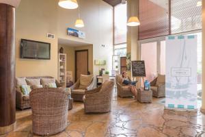 a woman sitting in a room with wicker chairs at Résidence Pierre & Vacances Premium Port Prestige in Antibes
