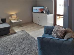 a living room with a blue couch and a tv at SP Luxury Loft 28 in Ravda