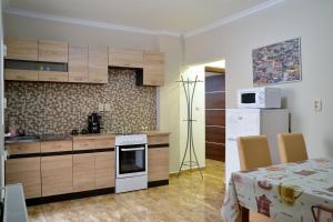 a kitchen with a table and a white stove top oven at Harmónia Belvárosi Apartmanok in Eger