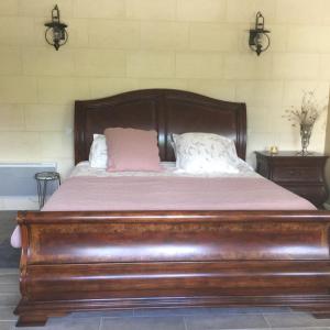 a wooden bed with two pillows on top of it at Chateau Couchebout in Pugnac
