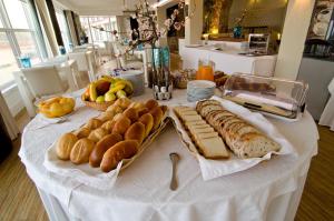 a table with bread and other foods on it at Estalagem Muchaxo Hotel in Cascais +67 photos