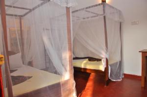 a bedroom with a canopy bed with white curtains at Cozy Crest in Ahangama +73 photos