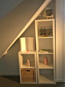ein Bücherregal unter der Treppe mit einer Box in der Unterkunft Studio Emilie in Detmold