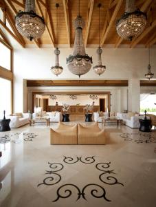 a large living room with couches and chandeliers at Mitsis Selection Blue Domes in Kardamaina