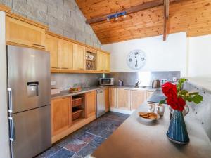 una cocina con nevera y un jarrón de flores en The Lodge at Raheengraney House en Cluain na nGall