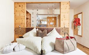 - une chambre avec un lit et des oreillers blancs dans l'établissement Hundehotel Riederhof, à Ried im Oberinntal