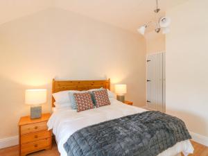 a bedroom with a large bed and two lamps at The Lodge at Raheengraney House in Cluain na nGall