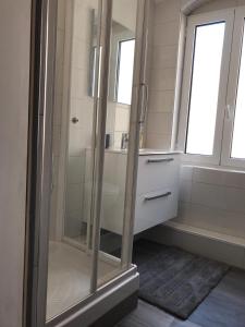 La salle de bains est pourvue d'une douche en verre et d'un lavabo. dans l'établissement Appartement à Ile Rousse, à LʼÎle-Rousse