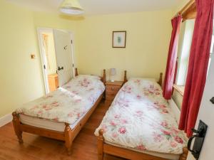 1 dormitorio con 2 camas y ventana en Cluaincarraig en Kilkelly