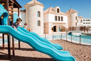 two children playing on a slide at a water park at Mitsis Selection Blue Domes in Kardamaina
