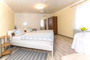 ein Schlafzimmer mit einem großen weißen Bett und einem Tisch in der Unterkunft Gasthof Zum Burgkrug in Leuchtenberg