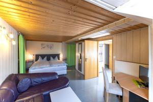 ein Schlafzimmer mit einem Bett und einer Couch in einem Zimmer in der Unterkunft Gasthof Zum Burgkrug in Leuchtenberg