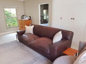 un sofá de cuero marrón en la sala de estar en Tranquil Tokai, en Tokai
