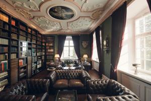 a living room with leather furniture and a coffered ceiling at Hotel Schloss Freudental in Allensbach