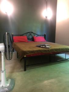 a bedroom with a bed with red pillows and a fan at BP Budget Rooms in Ko Mak