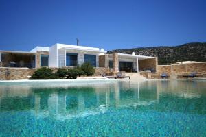 a villa with a swimming pool in front of a house at Villa Chelidonia in Karpathos