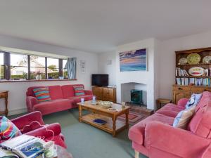a living room with red couches and a table at Sea Views in Swyre