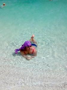 uma mulher com cabelo roxo e óculos de sol na água em Apartment Bella Rosa near the sea RedSeaLine em Hurghada