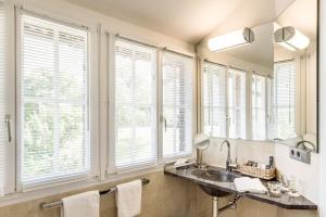 a bathroom with a sink and windows with towels at Hotel Schloss Freudental in Allensbach
