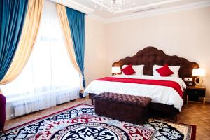 a bedroom with a large bed with red and white pillows at Boutique Hotel Silk Way in Türkistan