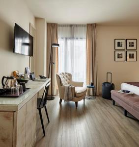 Habitación de hotel con escritorio con silla y cama en Hotel Barcelona Catedral en Barcelona