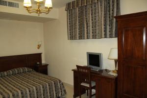 a bedroom with a bed and a desk with a computer at Hotel Domus in Altino