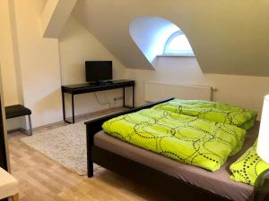 a bedroom with a bed and a desk with a television at Apartments Valencia in Karlovy Vary