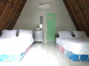 a bedroom with two beds and a sink in it at Bunar Tunggal Villa n Resto in Tanjung Lesung