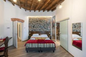 une chambre avec deux lits et un mur en pierre dans l'établissement Affittacamere Superior del Golfo e delle 5 Terre, à La Spezia