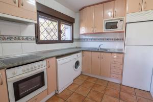 a kitchen with a white refrigerator and a dishwasher at Fuente del Pino Cañón de Río Lobos in San Leonardo de Yagüe
