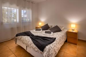 ein Schlafzimmer mit einem großen Bett mit zwei Lampen an Tischen in der Unterkunft Villa das Palmeiras in Charneca + 55 Fotos